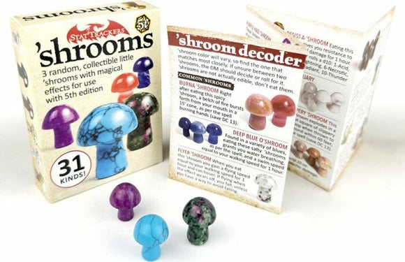 Stat Trackers: 'shrooms game by TopDog Games featuring three collectible mushroom figurines in various colors. The box shows the title and contains an informative card with a 'shroom decoder explaining the magical effects associated with each type of mushroom. The mushrooms are displayed in a clear arrangement, highlighting their unique colors and designs.