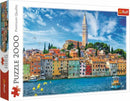 Trefl 2000-piece jigsaw puzzle featuring a vibrant view of Rovinj, Croatia, showcasing colorful coastal houses, a serene harbor, and a tall bell tower under a bright blue sky. Ideal for puzzle enthusiasts and lovers of travel.
