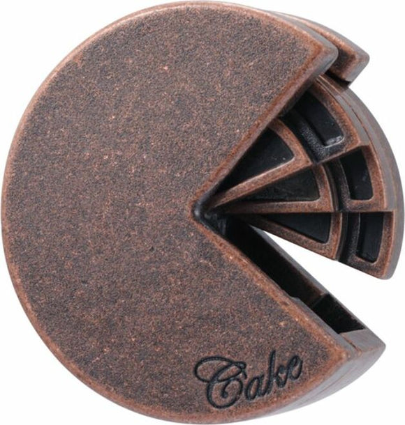 A cast metal mechanical puzzle designed by Hanayama, shaped like a slice of cake. The puzzle features intricate interlocking pieces and a rust-colored finish, showcasing both creativity and challenge for puzzle enthusiasts.