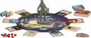 An image of the Avatar: The Last Airbender Fire Nation Rising board game by USAopoly. The game features a central circular game board showcasing a map of the Avatar world, surrounded by game cards, character tokens, and a detailed figure of a character from the Fire Nation. Colorful dice and additional components are scattered around, creating an engaging game setup.