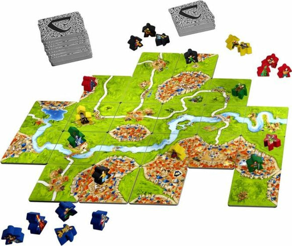 The Carcassonne 20th Anniversary game features a colorful landscape with tiles depicting cities, roads, and rivers. Players use various colored meeples to claim territory as they build their medieval kingdom. The game includes stacks of tiles and a variety of player pieces, presenting a vibrant and strategic gameplay experience.