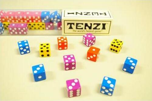 A colorful collection of dice in various colors including blue, pink, yellow, and green scattered on a light background. The game box labeled 'TENZI' is visible in the top center, showcasing the game as 'the world's fastest game'. Each die features unique dot patterns, enhancing the vibrant display and inviting gameplay.