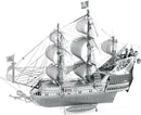 A detailed metal model of the Queen Anne's Revenge, a famous pirate ship. The ship features elaborate rigging, a skull and crossbones flag, and intricate designs on the hull, capturing the essence of naval history and adventure.