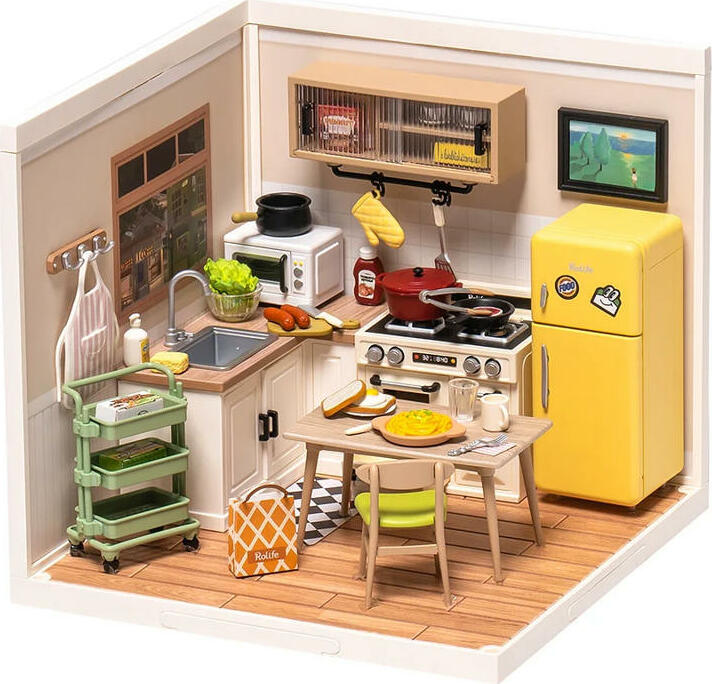 A detailed miniature kitchen setup from the Happy Meals Kitchen DIY Supers kit by Robortime. The scene features a bright yellow refrigerator, a stove with pots, a sink with fresh vegetables, and a dining table set with plates of food. The overall design showcases a cozy kitchen atmosphere with wooden flooring and several kitchen utensils, perfect for imaginative play and DIY crafting.