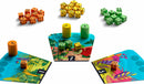 A vibrant game called Dandilions by Allplay, featuring colorful dice in orange, yellow, green, and blue. The game includes three illustrated boards with numbered areas and stacks of dice positioned strategically. The artistic design showcases lush foliage and playful graphics, inviting players to engage in a fun and interactive experience.