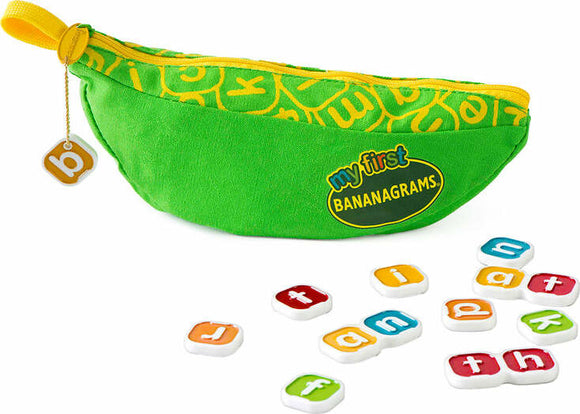 My First Bananagrams game features a bright green banana-shaped pouch with a yellow zipper, filled with letter tiles in various colors. The pouch is adorned with colorful letters and the Bananagrams logo, while several letter tiles are spread out in front, showcasing letters like 'd', 'j', and 'f'. This engaging educational game is designed for young children to enhance their spelling and vocabulary in a playful way.