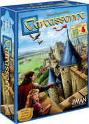 Carcassonne board game by Z-Man Games featuring detailed artwork. The box shows two characters in medieval attire looking at a castle with high towers and lush landscapes in the background. The packaging includes indications of mini expansions The River and The Abbot.
