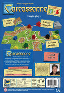 Carcassonne board game by Z-Man Games, featuring a vibrant design with tile placement mechanics. The back showcases gameplay instructions, components, and illustrations of the game elements, including meeples and a game board layout. This popular strategy game accommodates 2 to 5 players, emphasizing landscape creation and scoring tactics.