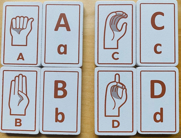 A set of Sign Language Alphabet Tiles, featuring raised letters A, B, C, and D alongside corresponding hand signs. Each tile is rectangular with a white textured background and brown illustrations of the letters and signs, designed for educational play.