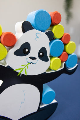 A playful wooden game featuring a cartoon panda balancing colorful stacked discs of red, blue, green, and yellow. The panda has a happy expression and is holding bamboo, showcasing a fun and engaging design perfect for children.