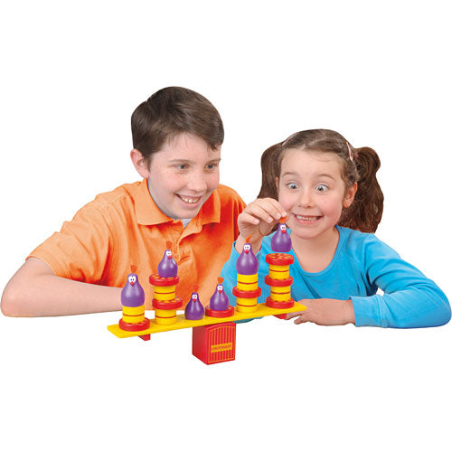 A boy and girl excitedly play with the Chickyboom game by Blue Orange U.S.A. The game features colorful wooden pieces, including purple chickens and a balancing platform. The children are engaged in a fun and interactive game, showcasing their joy and concentration while stacking and balancing the pieces.