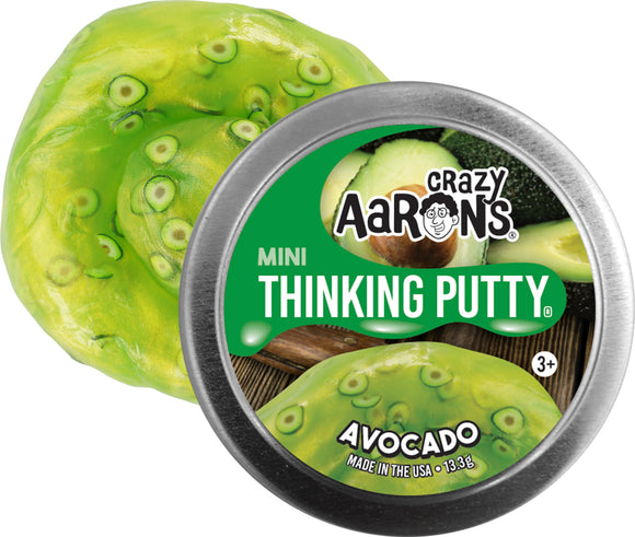 A tin of Crazy Aaron's Mini Avocado Thinking Putty. The putty is a vibrant green color with darker green speckles, resembling an avocado's texture. The tin lid features the brand name and product title prominently, with images of sliced avocados in the background.