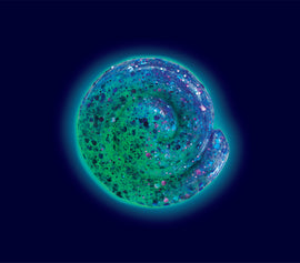 A vibrant 4-inch Thinking Putty in the Mermaid Tale design, showcasing a swirling blend of green, blue, and purple colors with glitter accents that resemble a shimmering ocean theme. The putty is shaped like a shell, reflecting a playful, marine-inspired aesthetic perfect for sensory play and stress relief.