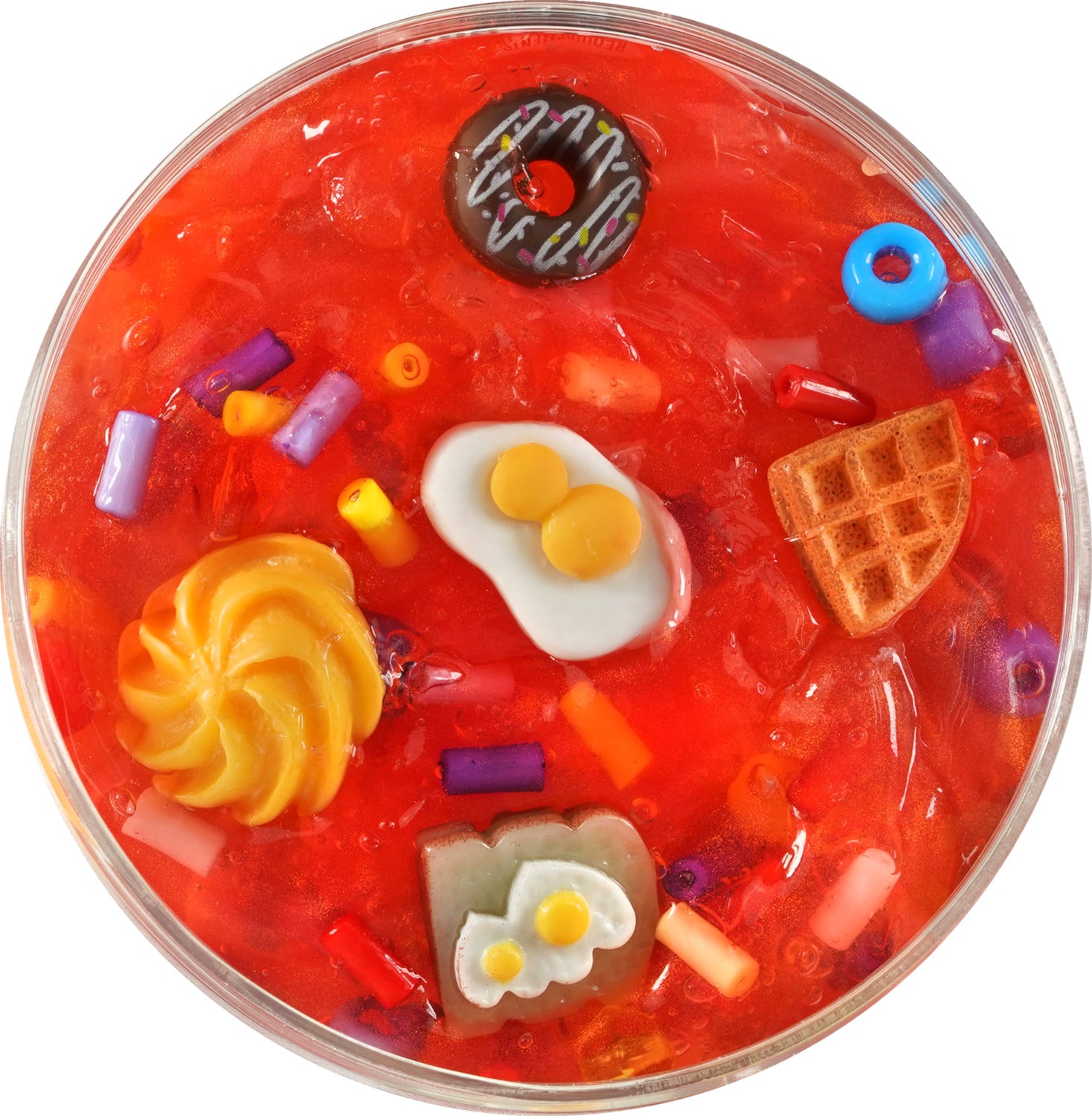 A vibrant, translucent red slime filled with various colorful food-themed charms, including a donut, waffles, and fried eggs, creating a fun, sensory experience.