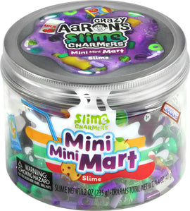 A clear container filled with colorful slime and various small charms. The product, Crazy Aaron's Mini Mini Mart Slime Charmers, features vibrant colors including purple, green, and yellow with small items like food and decorative charms. The lid displays the brand and product name prominently.