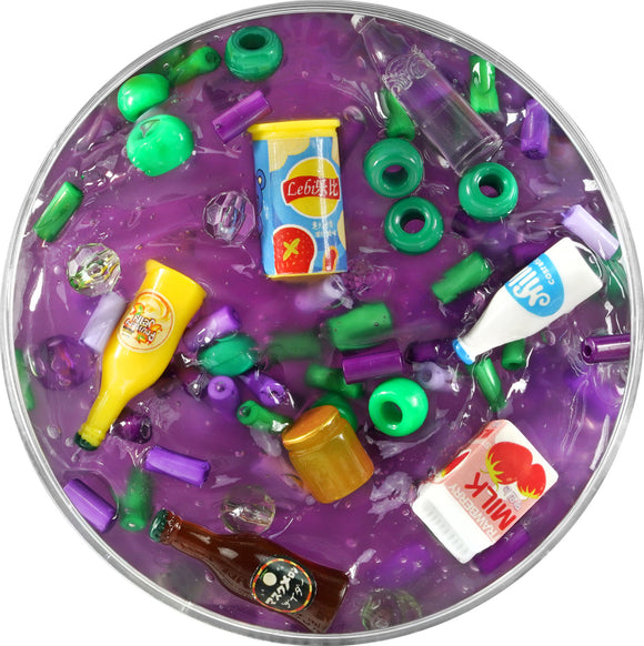 The Mini Mini Mart Slime Charmers by Crazy Aaron features vibrant purple slime filled with colorful charms resembling miniature food and beverage items, such as soft drink bottles and jars, offering a delightful tactile experience for stress relief and sensory play.