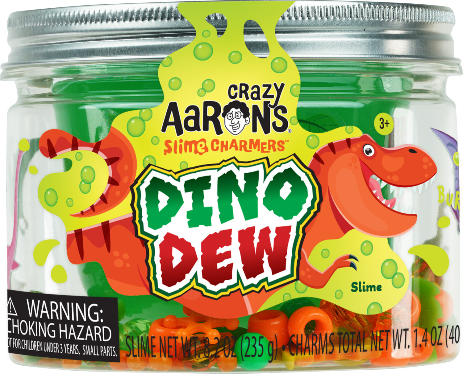 A clear jar of Crazy Aaron's Dino Dew Slime Charmers containing colorful slime and assorted dinosaur-shaped charms. The label features vibrant graphics of a friendly dinosaur and bubbles, indicating fun appeal for ages 3 and up.