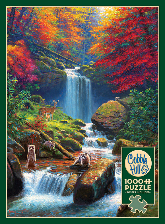 A beautifully illustrated jigsaw puzzle titled 'Mystic Falls in Autumn' by Cobble Hill. The scene features a vibrant autumn landscape with a cascading waterfall surrounded by colorful fall foliage. Various animals including deer and raccoons are depicted near the water and lush greenery, bringing the serene forest setting to life. The puzzle includes 1000 pieces and comes with a poster for reference.
