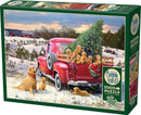 Cobble Hill jigsaw puzzle titled 'Family Outing', featuring a charming winter scene with a vintage red truck carrying a Christmas tree, surrounded by playful golden retriever puppies and a snowy landscape. Includes a poster.