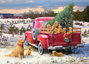 A vibrant jigsaw puzzle image titled 'Family Outing' featuring a red vintage truck filled with playful golden retriever puppies. The truck is parked in a snowy landscape adorned with a Christmas tree and surrounded by a farm setting with a barn in the background. The scene captures a joyful, heartwarming family outing atmosphere with snow-covered ground, evergreen trees, and playful dogs, perfect for family bonding through puzzle solving.