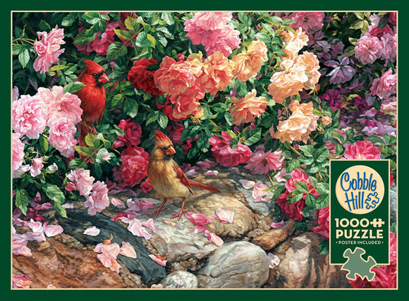 A colorful jigsaw puzzle featuring two cardinals among vibrant pink and yellow flowers. The design is intricate, filled with lush greenery and petals scattered on rocks, emphasizing nature's beauty. This 1000-piece puzzle by Cobble Hill also includes a poster.