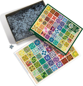 The product image showcases the Common Quilt Blocks jigsaw puzzle by Cobble Hill. The open puzzle box displays a colorful assortment of intricate quilt block designs on a puzzle board, with a portion of the jigsaw pieces visible inside the box. A single puzzle piece lies next to the box, highlighting the vibrant, detailed patterns in various colors and shapes, perfect for puzzle enthusiasts.