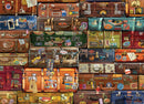 A colorful collection of vintage luggage with various travel stickers and labels, arranged closely together. The suitcases feature a range of colors including orange, blue, green, and brown, all decorated with travel memorabilia such as tags and postcards, evoking a nostalgic travel theme.