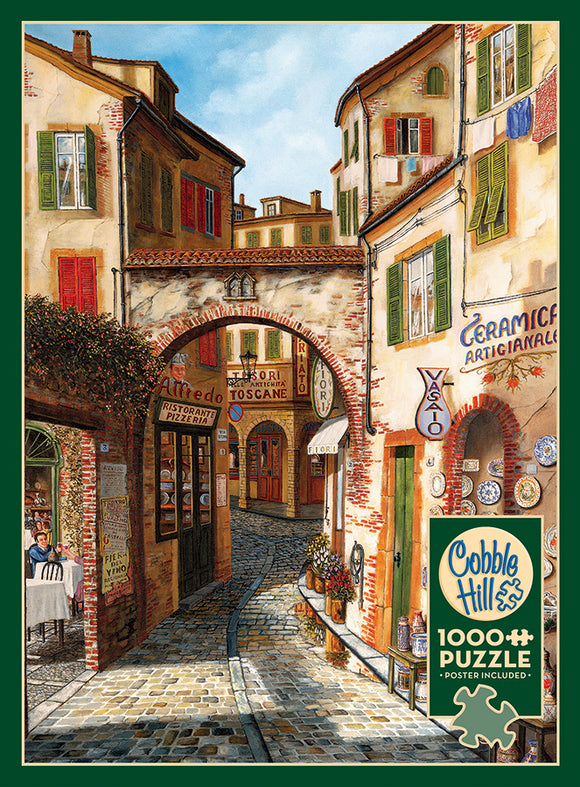 A 1000-piece jigsaw puzzle by Cobble Hill featuring a scenic street view titled 'Ceramica.' The artwork depicts charming buildings with colorful shutters and an archway. Restaurants and shops line the cobbled street, creating a warm, inviting atmosphere. A poster is included with the puzzle.