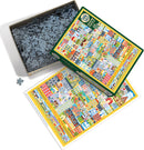 Cobble Hill's Home Sweet Home jigsaw puzzle features a vibrant illustration of colorful houses and whimsical buildings. The puzzle comes in a sturdy box, accompanied by an image of the completed design. An additional loose piece is shown beside the box, emphasizing the jigsaw's charm and intricate design.
