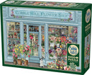 The Cobble Hill 'Parisian Flowers' jigsaw puzzle, featuring a beautifully illustrated flower shop exterior filled with vibrant flowers in pots. The puzzle has 1000 pieces and includes a poster for reference. A cute dog is seen at the entrance, adding charm to the scene.