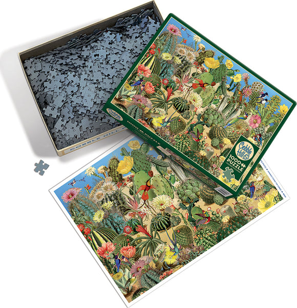 A vibrant jigsaw puzzle titled 'Cactus Garden' by Cobble Hill, displayed in an open box. The puzzle features intricate illustrations of various cacti, flowers, and plants in a colorful landscape. The image includes a close-up view of some puzzle pieces alongside the box.