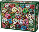 A colorful jigsaw puzzle featuring an assortment of decorated sugar skull cookies. The cookies are intricately designed with vibrant colors, flowers, and faces, displayed against a patterned background. This 1000-piece puzzle includes a poster and is part of the Cobble Hill collection.