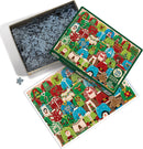 Cobble Hill Ugly Xmas Sweaters jigsaw puzzle with a colorful design featuring various Christmas sweaters in red, green, and blue, showing festive motifs like snowmen, Santa, and Christmas trees. The puzzle comes in a decorative box with some pieces scattered around it, hinting at the fun challenge of assembling 1000 pieces.