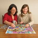 Two women enjoying a fun afternoon while working on the Doodlecats jigsaw puzzle. One woman in a red shirt holds a mug, while the other in a cozy sweater places a piece on the colorful puzzle. Various pieces are scattered on the wooden table, showcasing the vibrant graphics of the puzzle. The atmosphere is lively and engaging, perfect for friends or family gatherings.