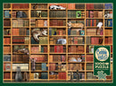A colorful jigsaw puzzle titled 'The Cat Library' by Cobble Hill, featuring a detailed image of a bookshelf filled with various books and playful cats lounging among them. The puzzle contains 1000 pieces and includes a poster for reference.