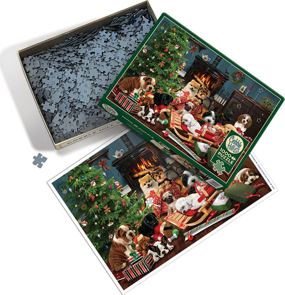 A colorful jigsaw puzzle titled 'Christmas Puppies' by Cobble Hill, featuring a festive scene with various breeds of puppies playing around a decorated Christmas tree, surrounded by gifts and holiday decorations. The puzzle pieces are spread out in a box, showcasing their unique shapes, while the box itself displays the vibrant image of the completed puzzle and its festive atmosphere.
