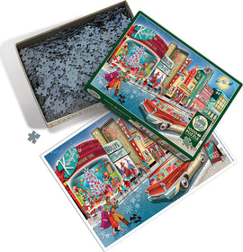 The Vintage Main Street jigsaw puzzle by Cobble Hill features a colorful nostalgic scene depicting a festive winter street filled with holiday decorations, a classic car, and people enjoying the season. The image shows the puzzle box open with scattered pieces and an art print of the completed scene beside it, capturing the charm of a vintage town during the holiday season.