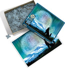A Cobble Hill jigsaw puzzle titled 'Two Wolves'. The box features an artistic design with two wolves silhouetted against a mountainous landscape under a colorful sky. The lid of the box partially reveals puzzle pieces inside, while the included puzzle image showcases the wolves and the serene northern landscape.