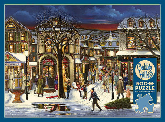 A festive winter scene depicting a bustling town square during the holiday season. The image features charming shops adorned with holiday decorations, people walking around carrying shopping bags, children building a snowman, and snow-covered trees under a twilight sky. This cozy atmosphere is perfect for jigsaw puzzle lovers. The Cobble Hill puzzle includes 500 pieces and a poster.