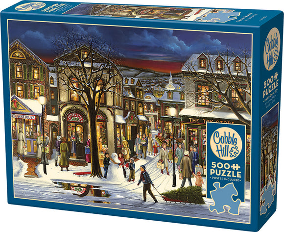 A colorful jigsaw puzzle titled 'Tis the Season' by Cobble Hill, featuring a winter street scene bustling with people, shops, and holiday decorations. The 500-piece puzzle includes a poster for reference.