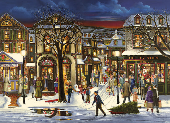 A beautifully illustrated jigsaw puzzle titled 'Tis the Season by Cobble Hill, featuring a wintery village scene with bustling streets decorated for the holidays. Shoppers are seen carrying gifts, a snowman stands cheerfully in the background, and charming storefronts exude a festive atmosphere with lights and decorations.