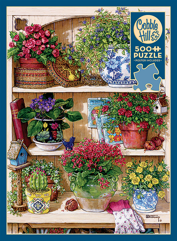 The Flower Cupboard jigsaw puzzle by Cobble Hill features a vibrant and intricate illustration of a wooden shelf adorned with various potted flowers, plants, and decorative items. The scene showcases colorful pots of roses, violets, and other greenery, complemented by a background of books and garden-themed decorations. This 500-piece puzzle includes a poster for reference, making it a delightful challenge for puzzle enthusiasts.