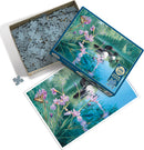 A glimpse of the Cobble Hill Iris Cove Loons jigsaw puzzle. The box features a vibrant image of loons on a serene lake surrounded by blooming irises and a butterfly. The puzzle pieces are packed in the box with some scattered around. The illustration showcases nature's beauty, making it perfect for puzzle enthusiasts who enjoy wildlife themes.