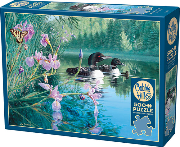 Iris Cove Loons jigsaw puzzle box featuring a serene nature scene with two loons swimming among vibrant purple irises and a colorful butterfly. The water reflects lush greenery, enhancing the tranquil atmosphere. The puzzle contains 500+ pieces and includes a poster.