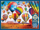 A vibrant jigsaw puzzle titled 'Up in the Air' featuring a stunning scene of colorful hot air balloons soaring over a desert landscape under a bright blue sky. The image showcases a variety of balloon designs and colors, creating a cheerful and adventurous atmosphere. This 500-piece puzzle by Cobble Hill includes a poster for reference during assembly.