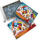 A jigsaw puzzle titled 'Up in the Air' by Cobble Hill. The box features colorful hot air balloons against a vibrant landscape. The puzzle pieces are shown scattered and organized within the box, with a close-up of a puzzle piece. The completed puzzle image is partially visible, showcasing bright colors and a scenic sky.
