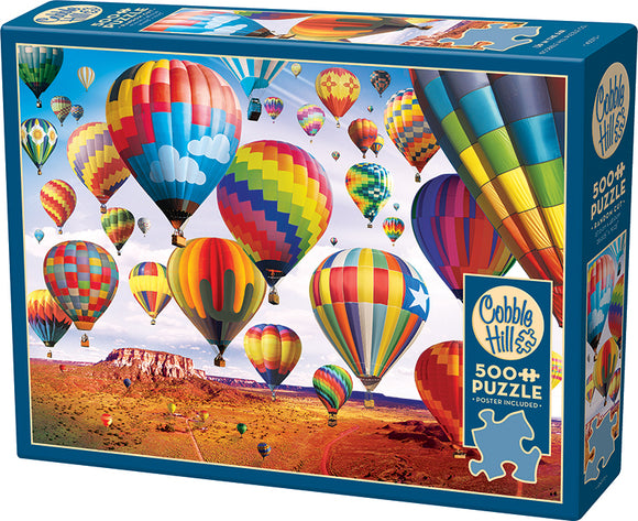 Cobble Hill jigsaw puzzle titled 'Up in the Air' featuring a vibrant scene of colorful hot air balloons soaring above a scenic desert landscape. The puzzle contains 500 pieces and includes a poster for reference. Perfect for puzzle enthusiasts and family fun.