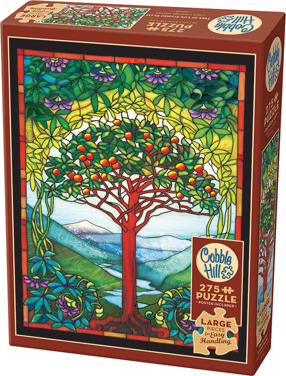 Cobble Hill Tree of Life Stained Glass jigsaw puzzle featuring colorful stained glass artwork of a vibrant tree surrounded by lush green foliage and mountains in the background. The puzzle includes 275 large pieces for easy handling and also comes with a poster for reference.