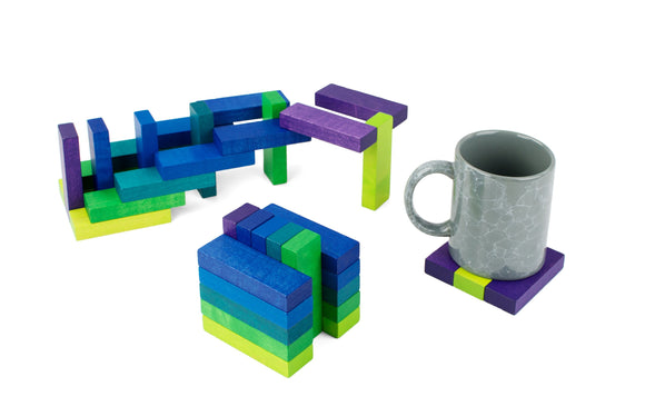 The Playable ART Coaster Cube SEA features colorful wooden blocks in various shapes that can be rearranged to create unique designs and patterns. The set includes a grey mug positioned on a vibrant coaster made from the blocks. Ideal for creative play and mindfulness, this versatile puzzle makes a fun and engaging decorative piece for any space.