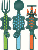 Colorful children's utensil set featuring dinosaur-themed designs. The set includes a fork shaped like a dinosaur tail, a spoon with a textured surface for grip, and a playful knife resembling a dinosaur head. Each utensil is bright green and orange, making mealtime fun for kids.